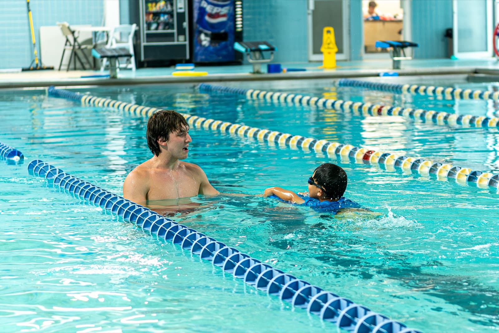 SafeStroke instructor working one-on-one with a young swimmer at the pool