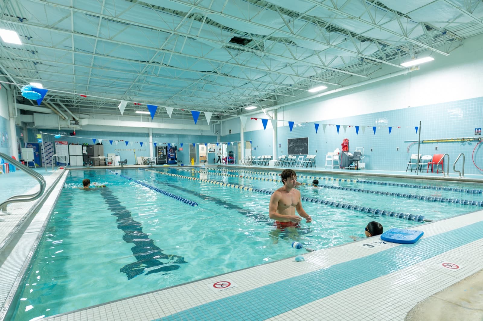 Coach watching closely as a young swimmer practices technique